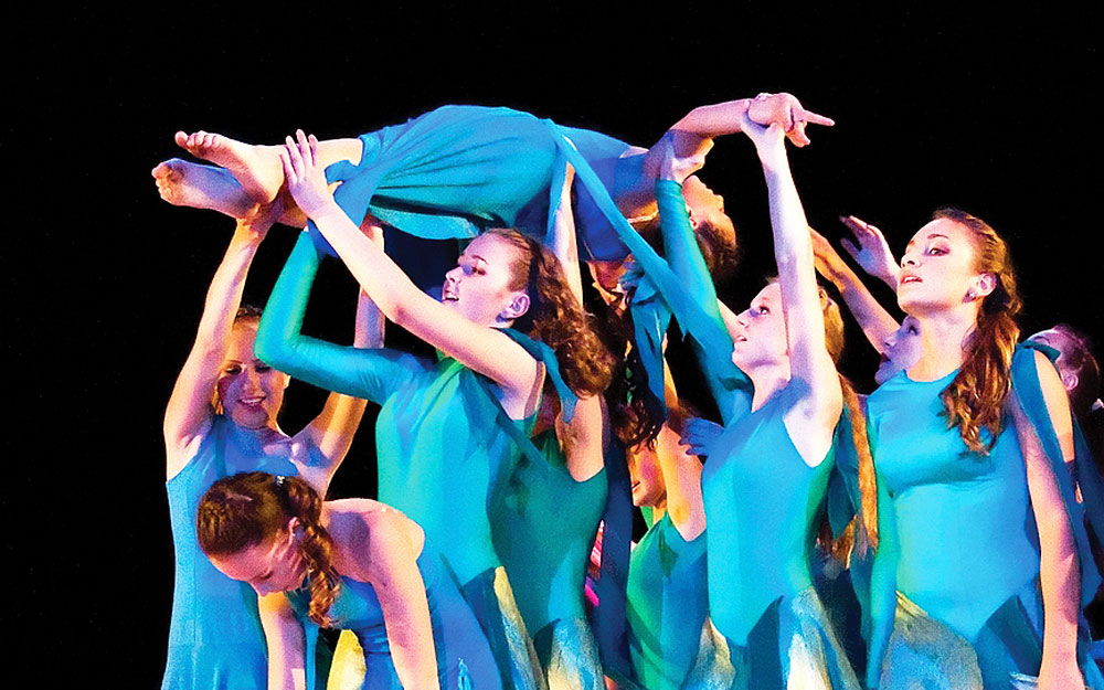 Girls in blue dresses performing arts