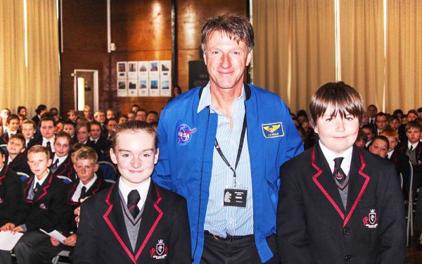 NASA employee next to two students for a photo