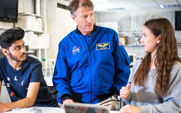 NASA employee talking to 2 seated students