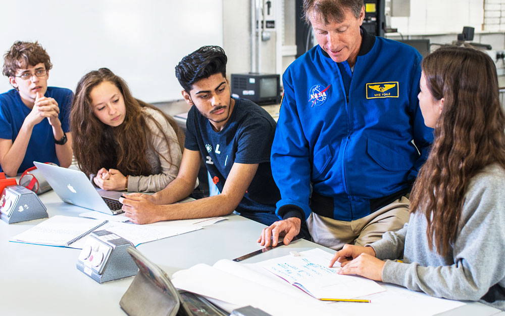 NASA employee talking to 4 seated students